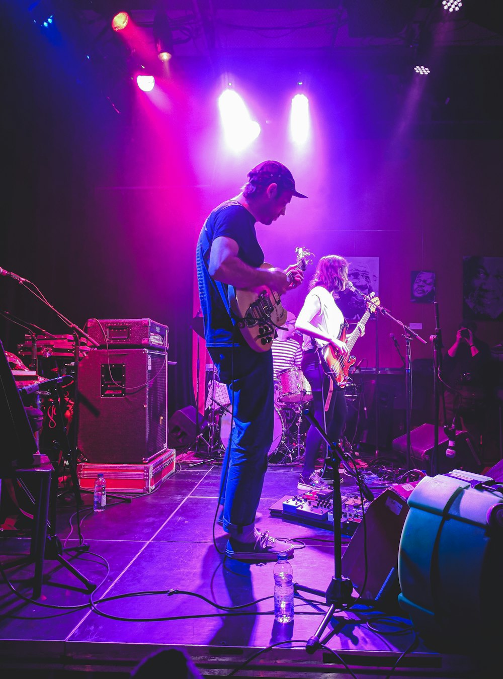 man in blue t-shirt playing guitar on stage