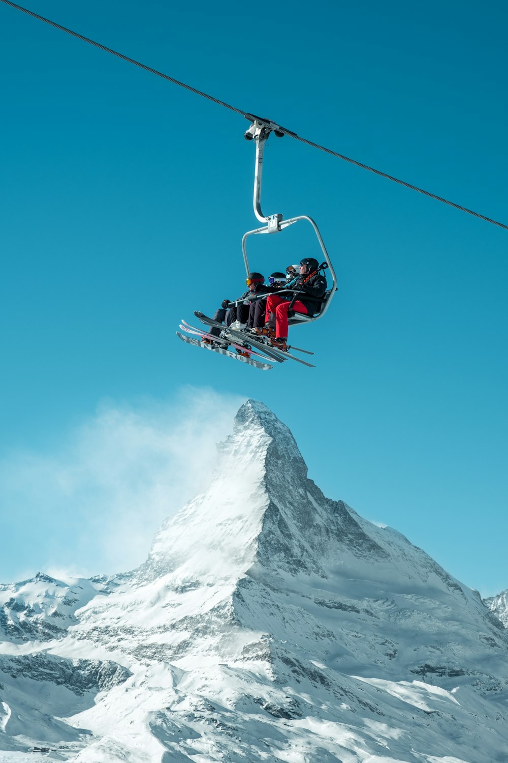 Mensen in een skilift met een berg op de achtergrond