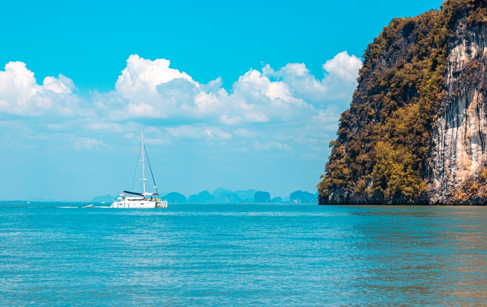 white sailboat on blue sea under blue sky during daytime