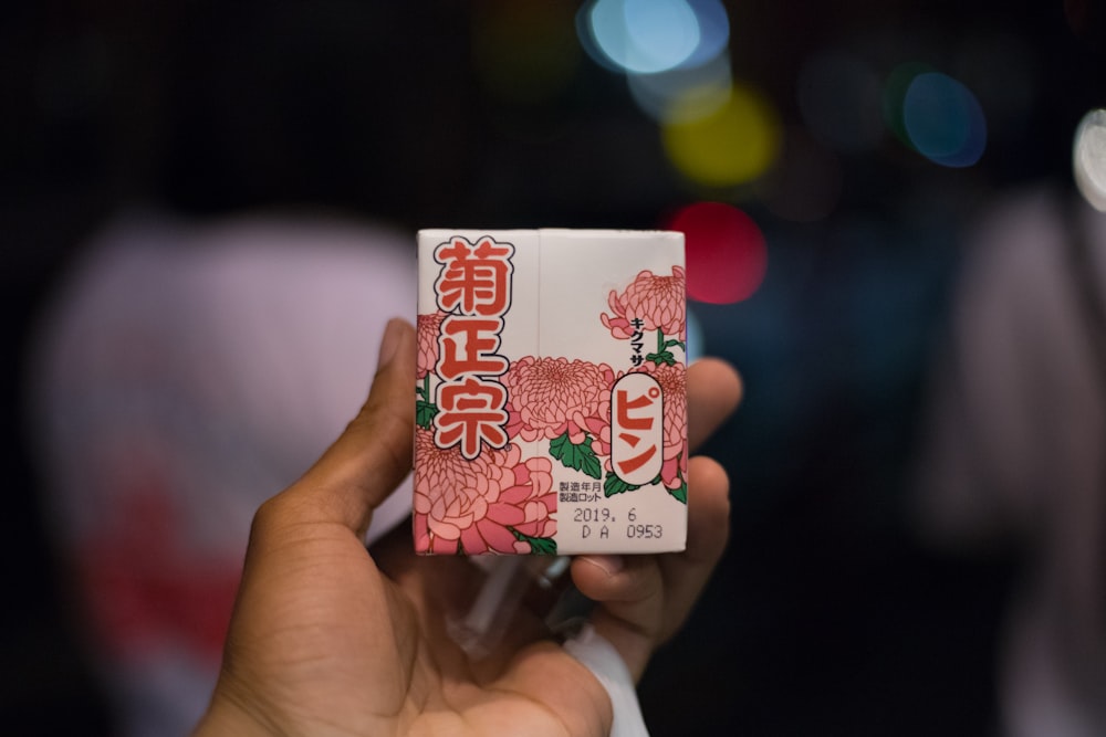 person holding white and red strawberry card