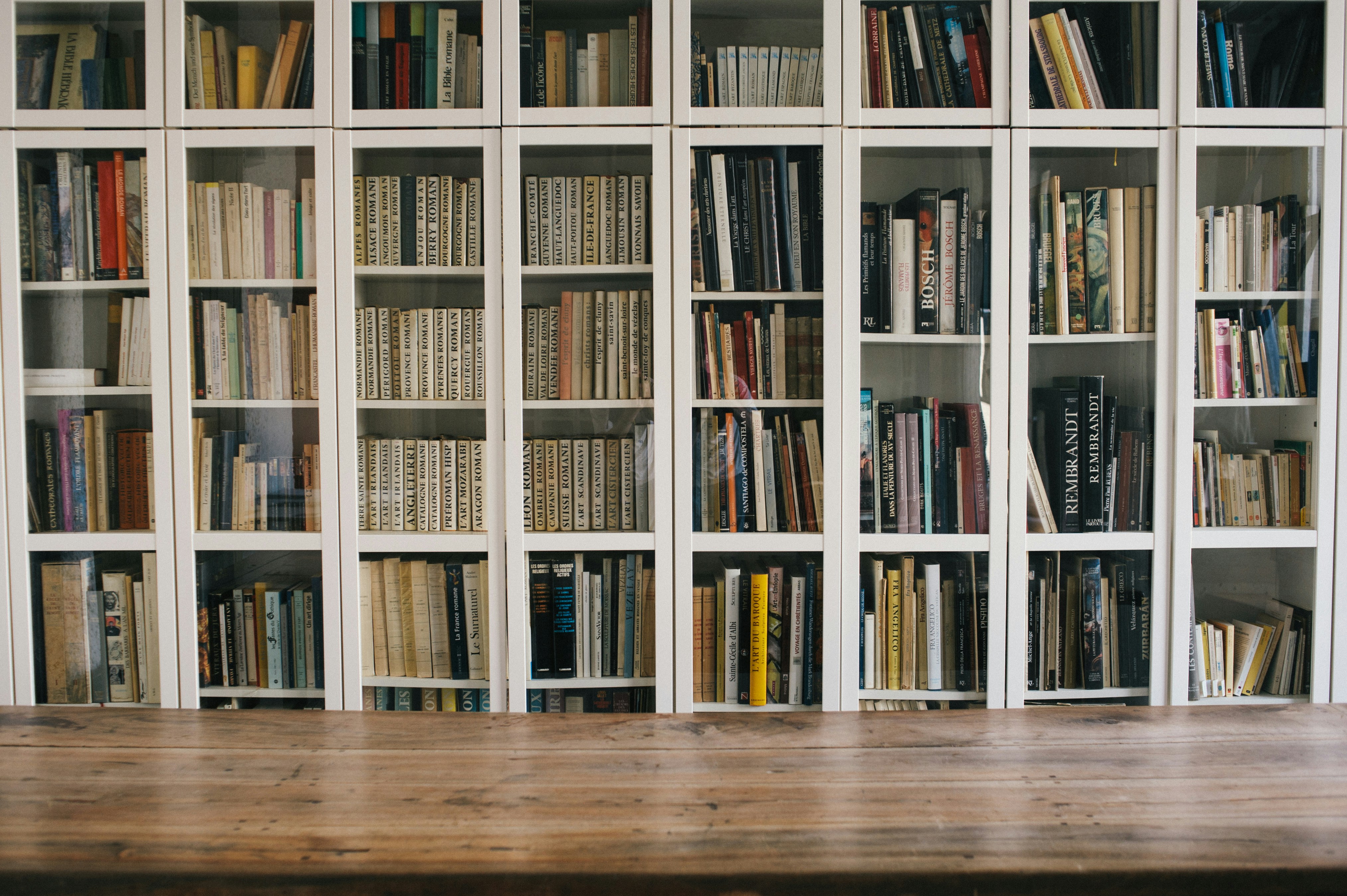 library bookshelves with modern laptop open on table