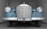 Front view of a vintage Mercedes-Benz car with a blue body and chrome accents. The car is indoors, positioned in a narrow, white-walled space. The license plate reads 'RJY 1761'.