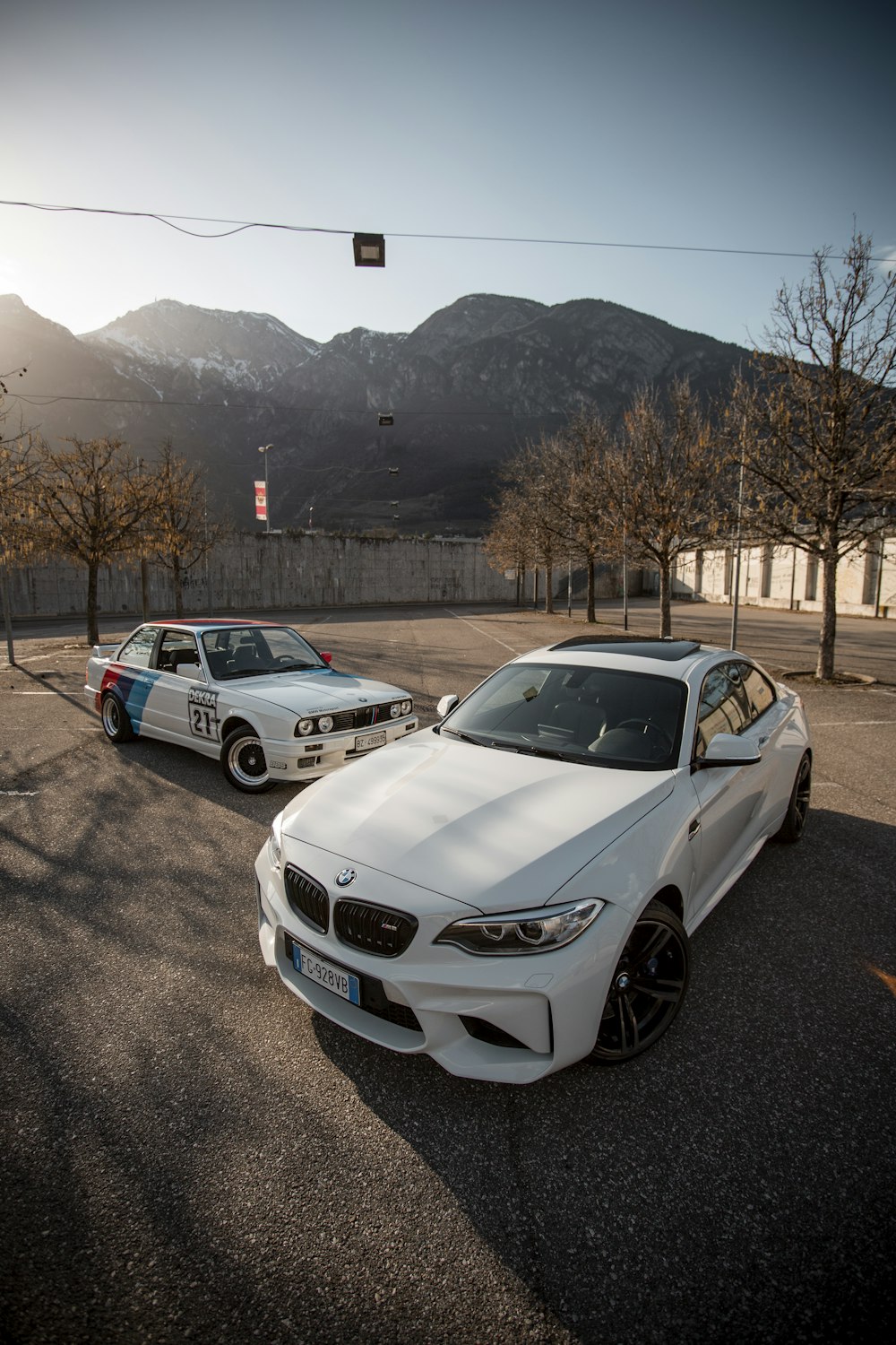 Auto BMW bianca parcheggiata sulla strada asfaltata grigia durante il giorno