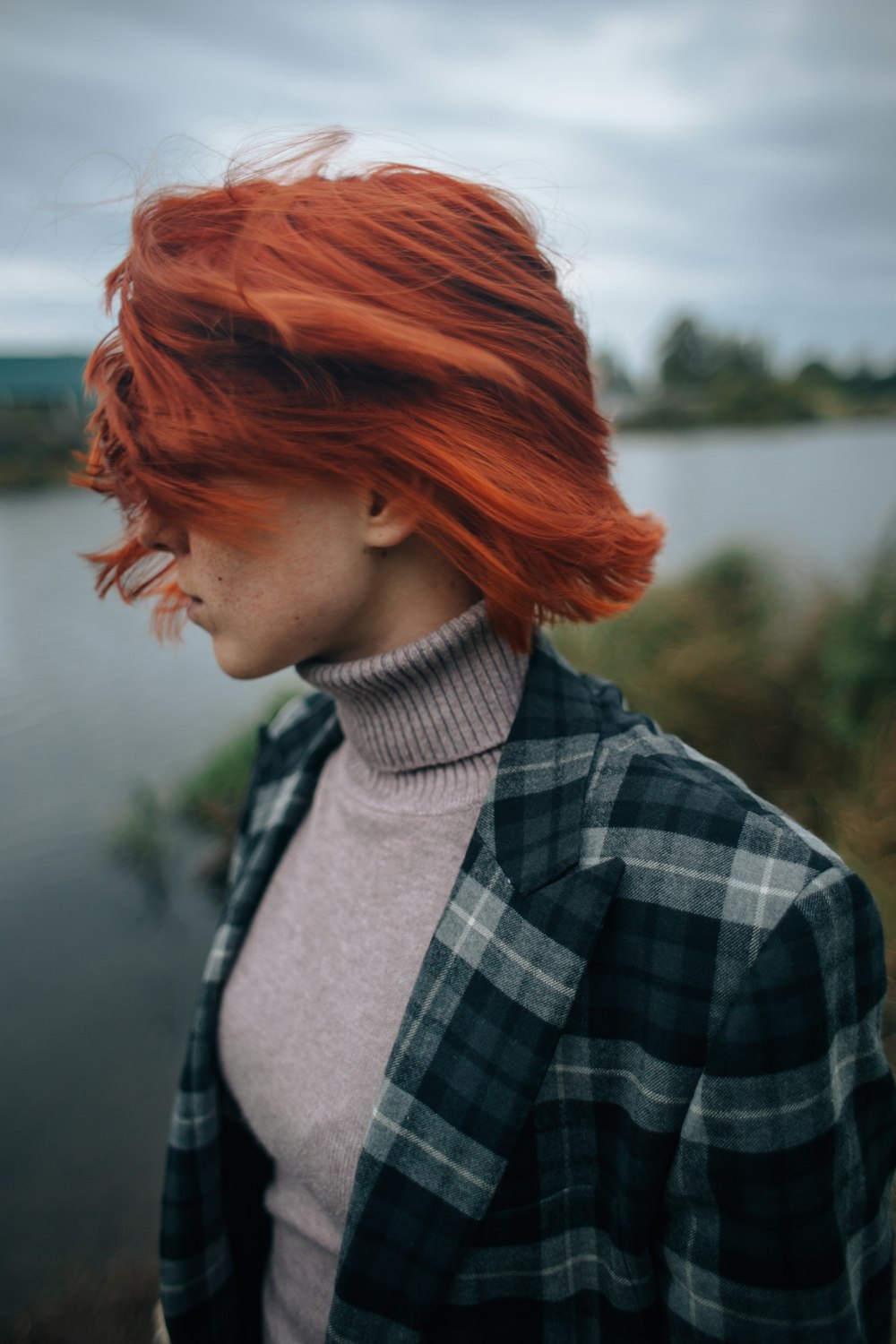 mulher na camisa xadrez preta e branca com cabelo vermelho