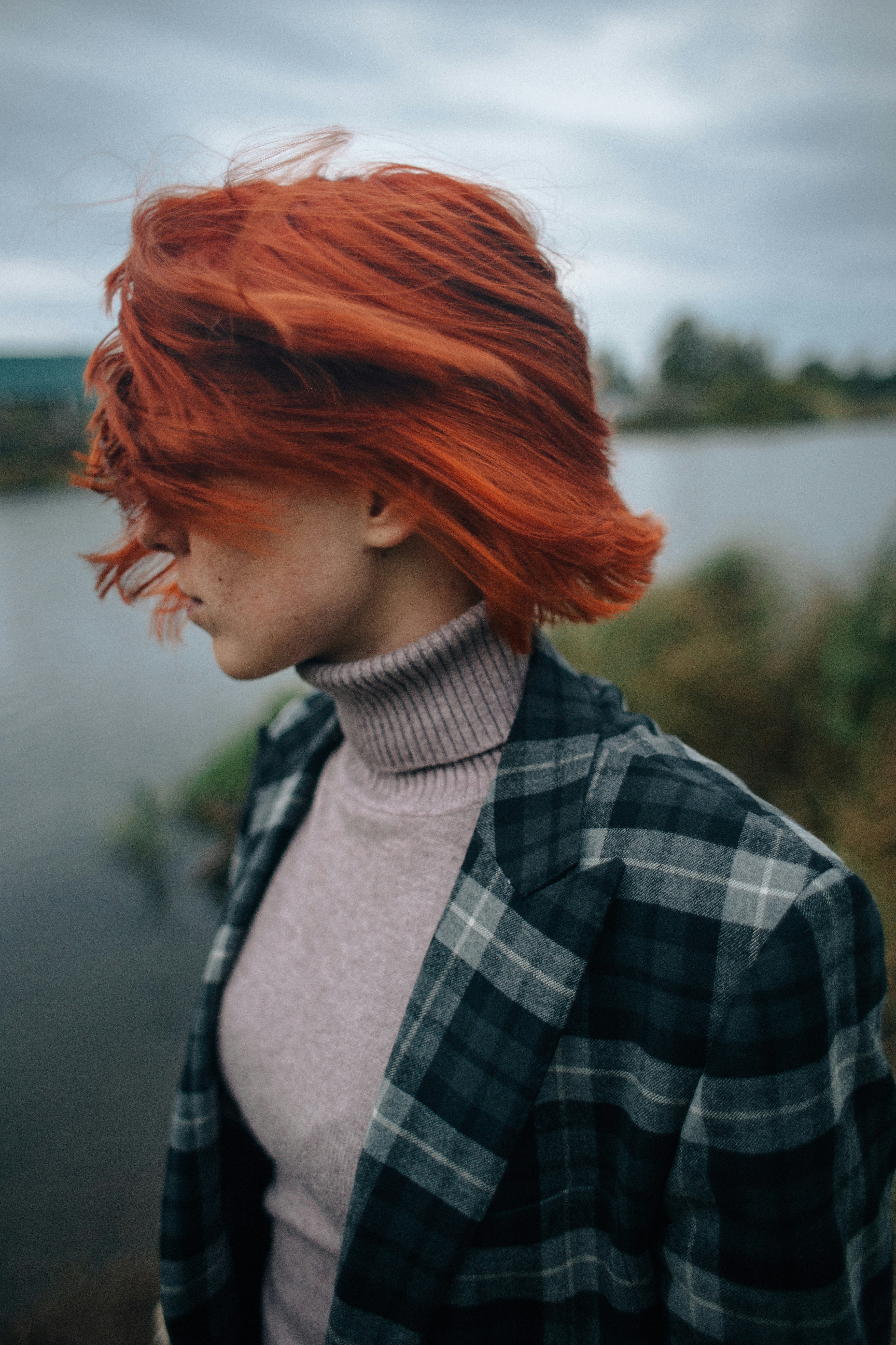 woman in black and white plaid shirt with red hair