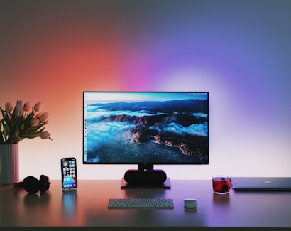 black flat screen computer monitor on brown wooden desk