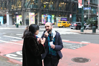 A friendly outreach representative engaging in a warm conversation with a passerby on a busy Toronto street.