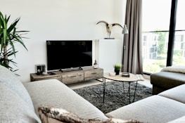 black flat screen tv on brown wooden tv rack