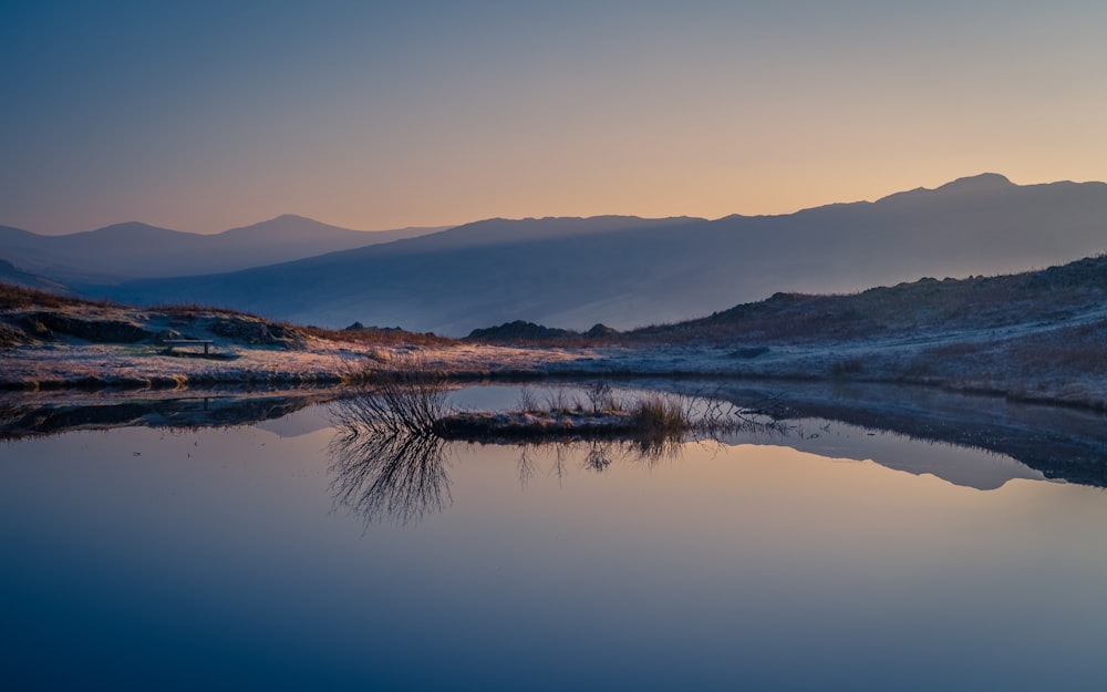 body of water near mountain during daytime