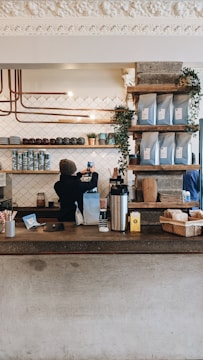 Coffee shop counter with barista preparing fresh coffee drinks.