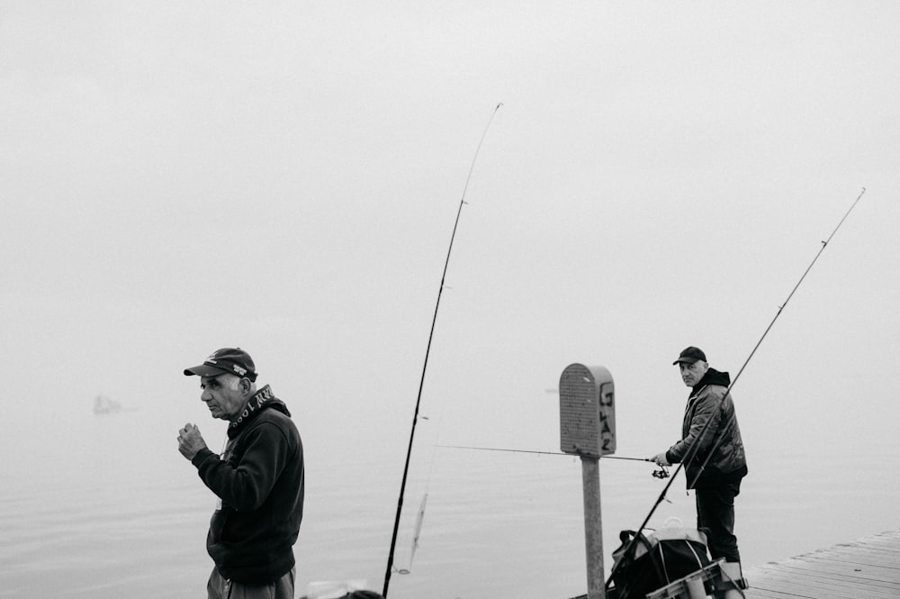 man in black jacket and gray cap holding black dslr camera