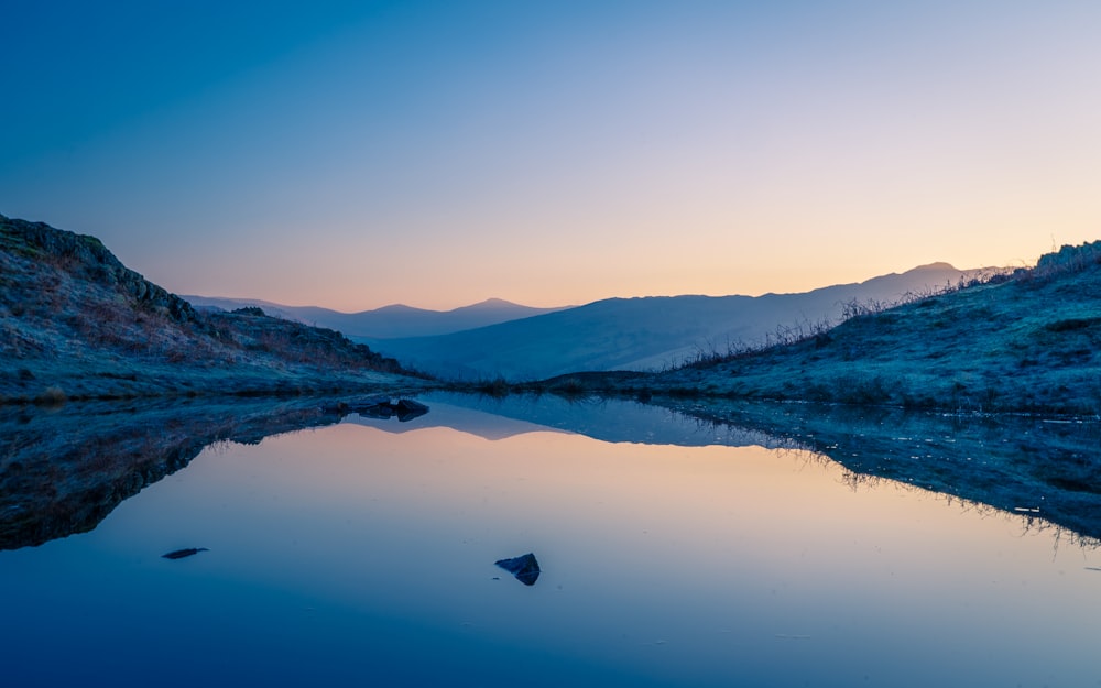 lake in the middle of mountains during daytime