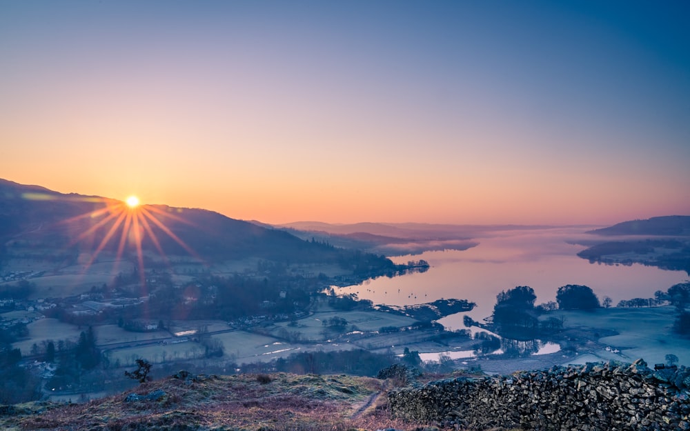 Weiße und schwarze Häuser in der Nähe von Bergen während des Sonnenuntergangs