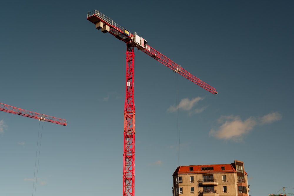 red and white crane under blue sky during daytime