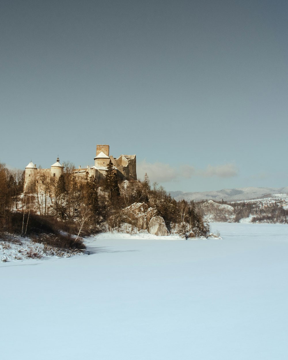 brown concrete building on snow covered ground during daytime