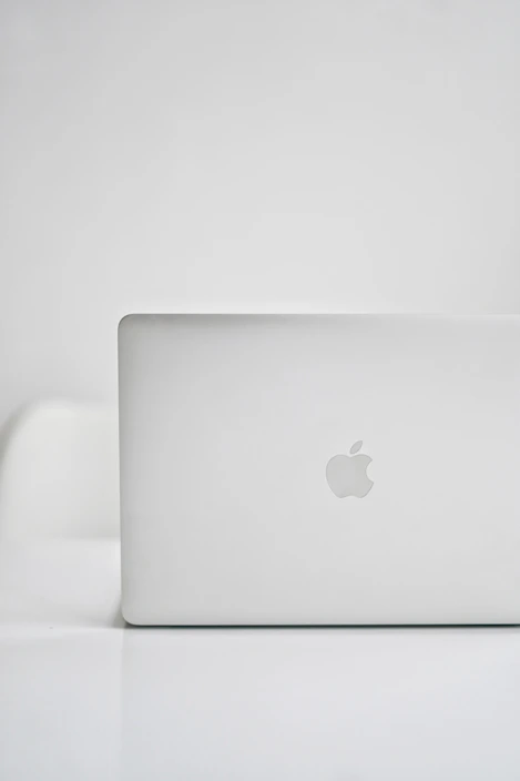 Close-up of a silver MacBook with a clean, modern aesthetic in monochrome tones