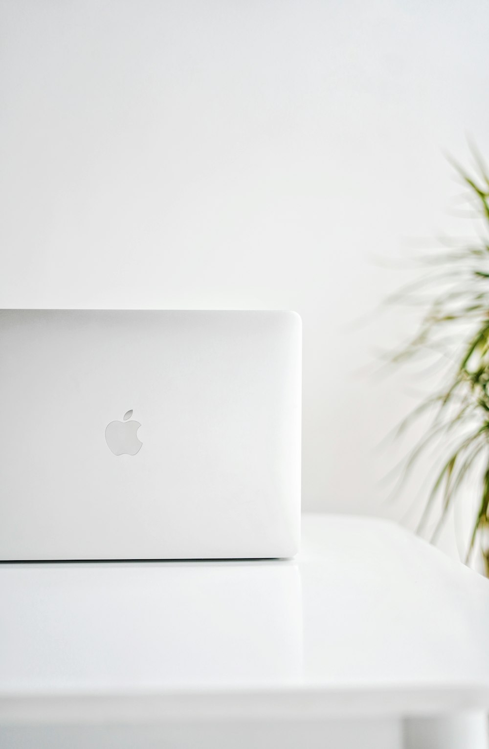 silver macbook on white textile