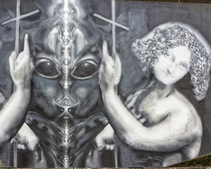 A surreal artwork featuring a figure reminiscent of an alien with large eyes and smooth skin, flanked by an androgynous human figure with curly hair. Both figures appear to be holding crosses, creating a mystical and otherworldly scene.