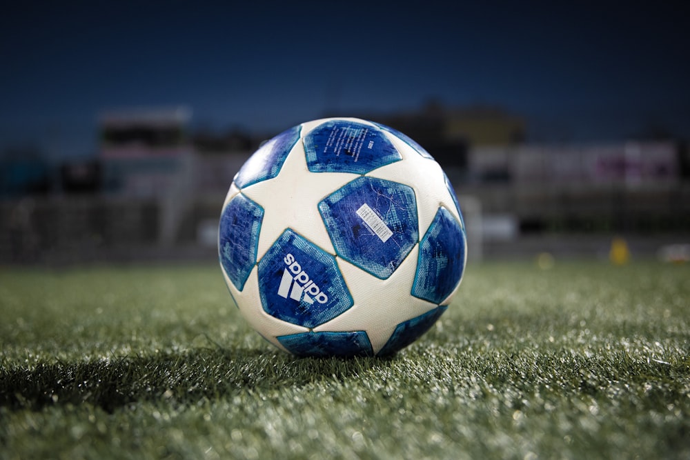 Ballon de football blanc et bleu sur un terrain en herbe verte