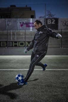 An African soccer player training on a European football field during a trial.