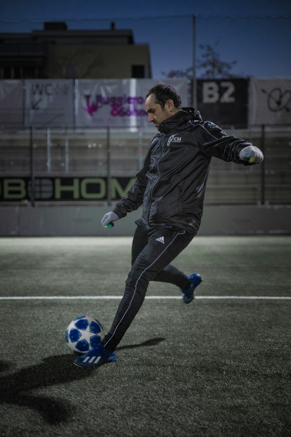 man in black leather jacket and black pants playing soccer