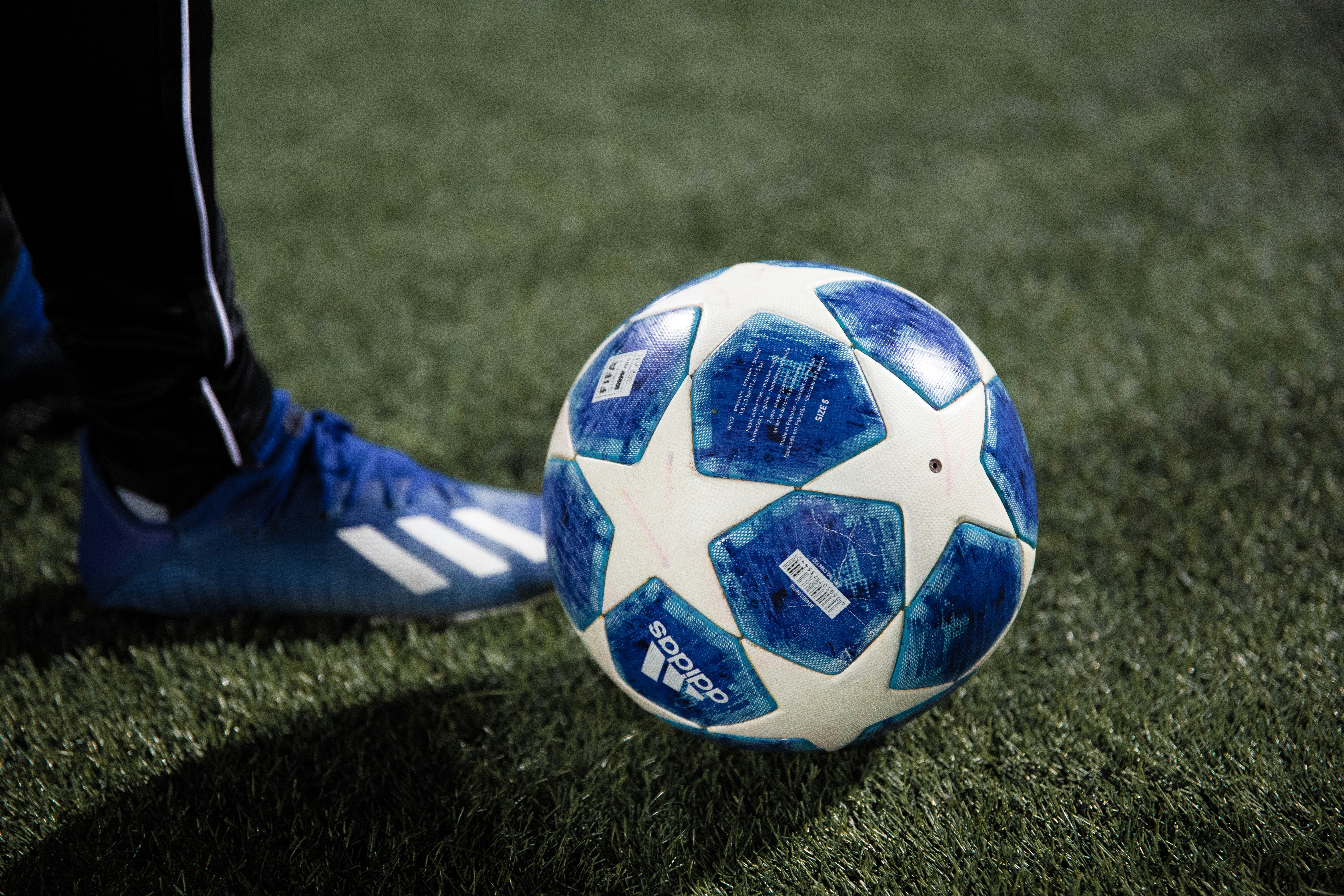 blue and white soccer ball on green grass field