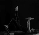 woman in black pants and black boots lying on black wooden bench