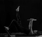 woman in black pants and black boots lying on black wooden bench