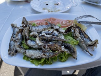 A rustic seaside restaurant serving fresh grilled fish with lemon wedges.