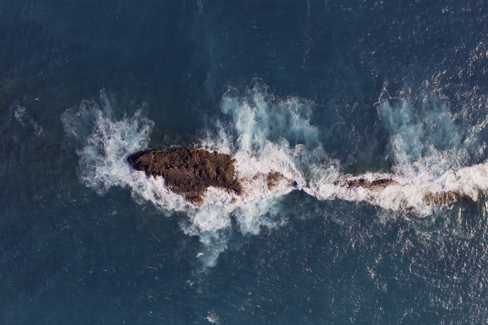 brown rock formation on blue water