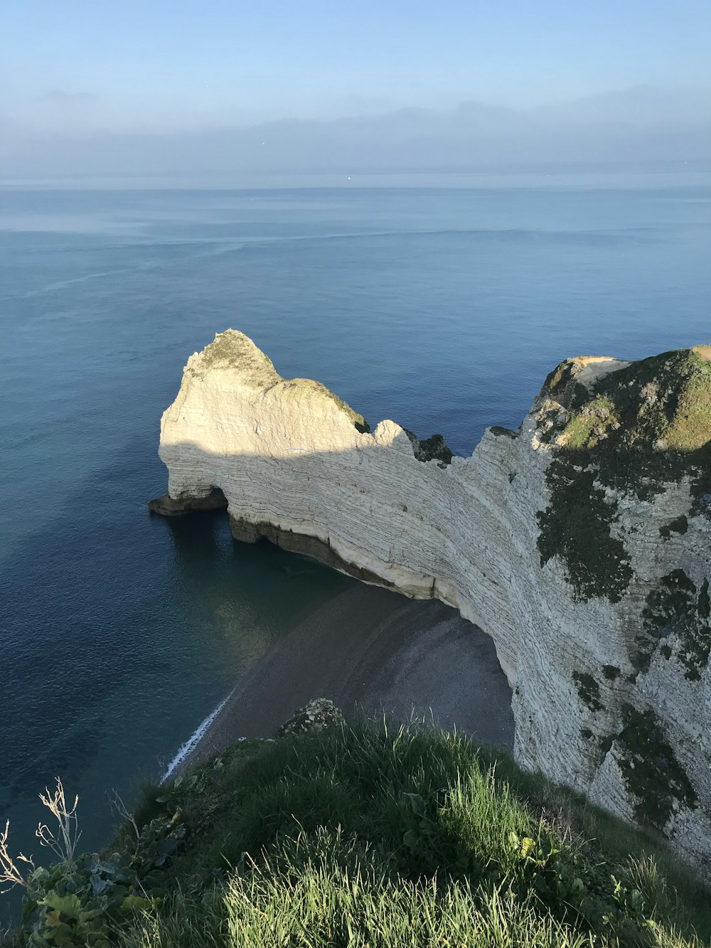 formazione rocciosa bianca accanto al mare blu durante il giorno