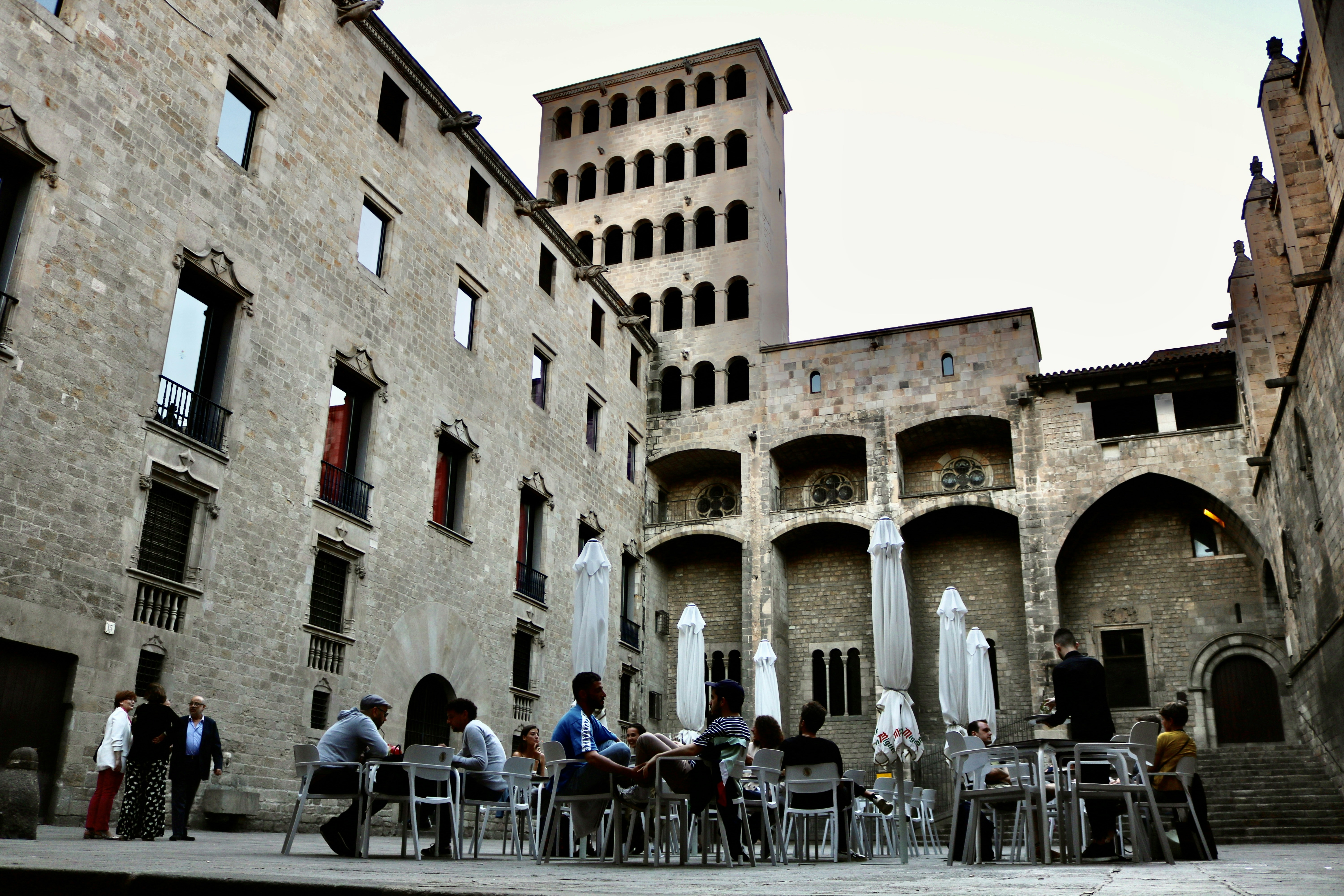 people sitting on chair near building during daytime