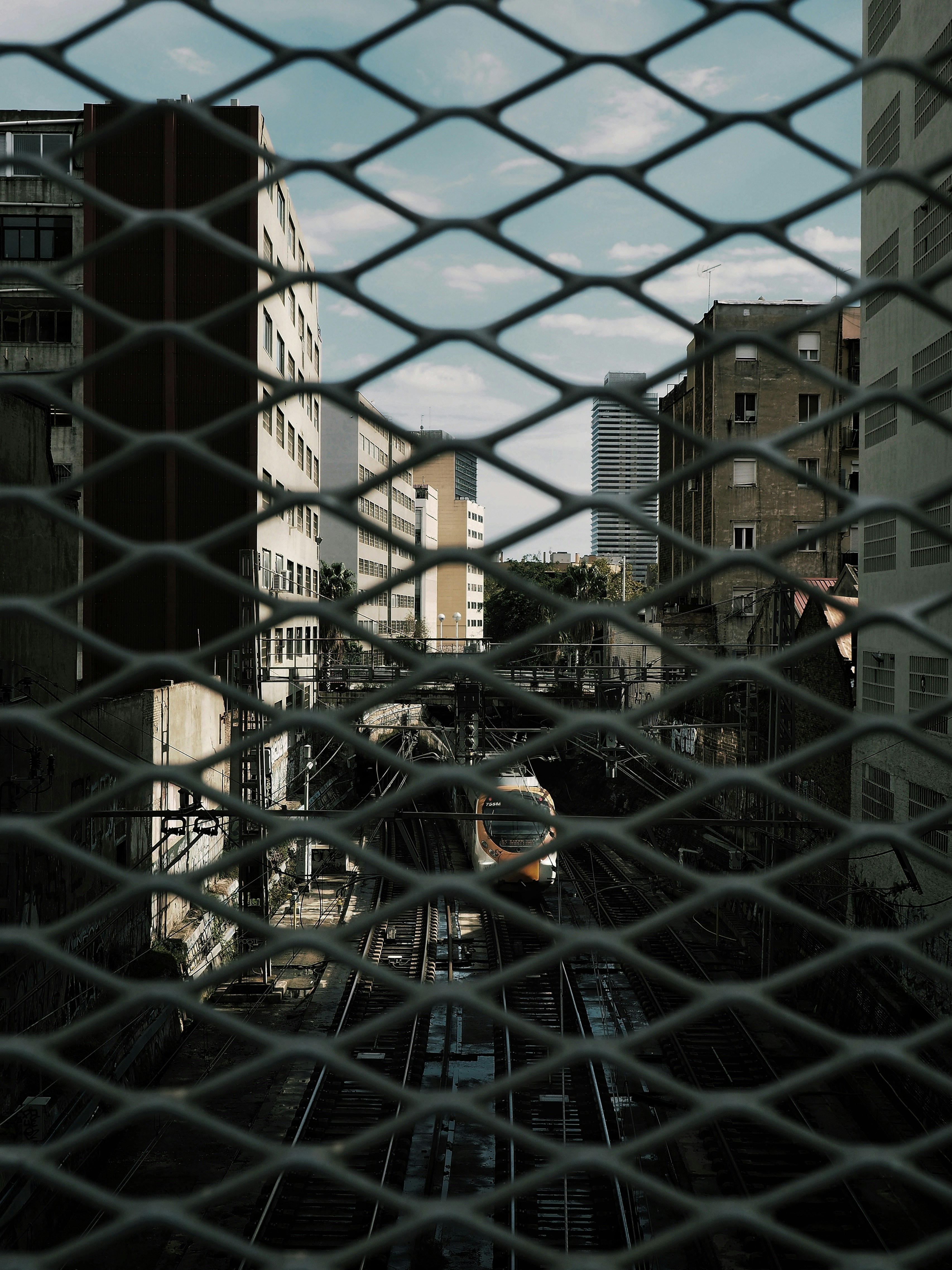 black metal mesh fence near brown concrete building during daytime