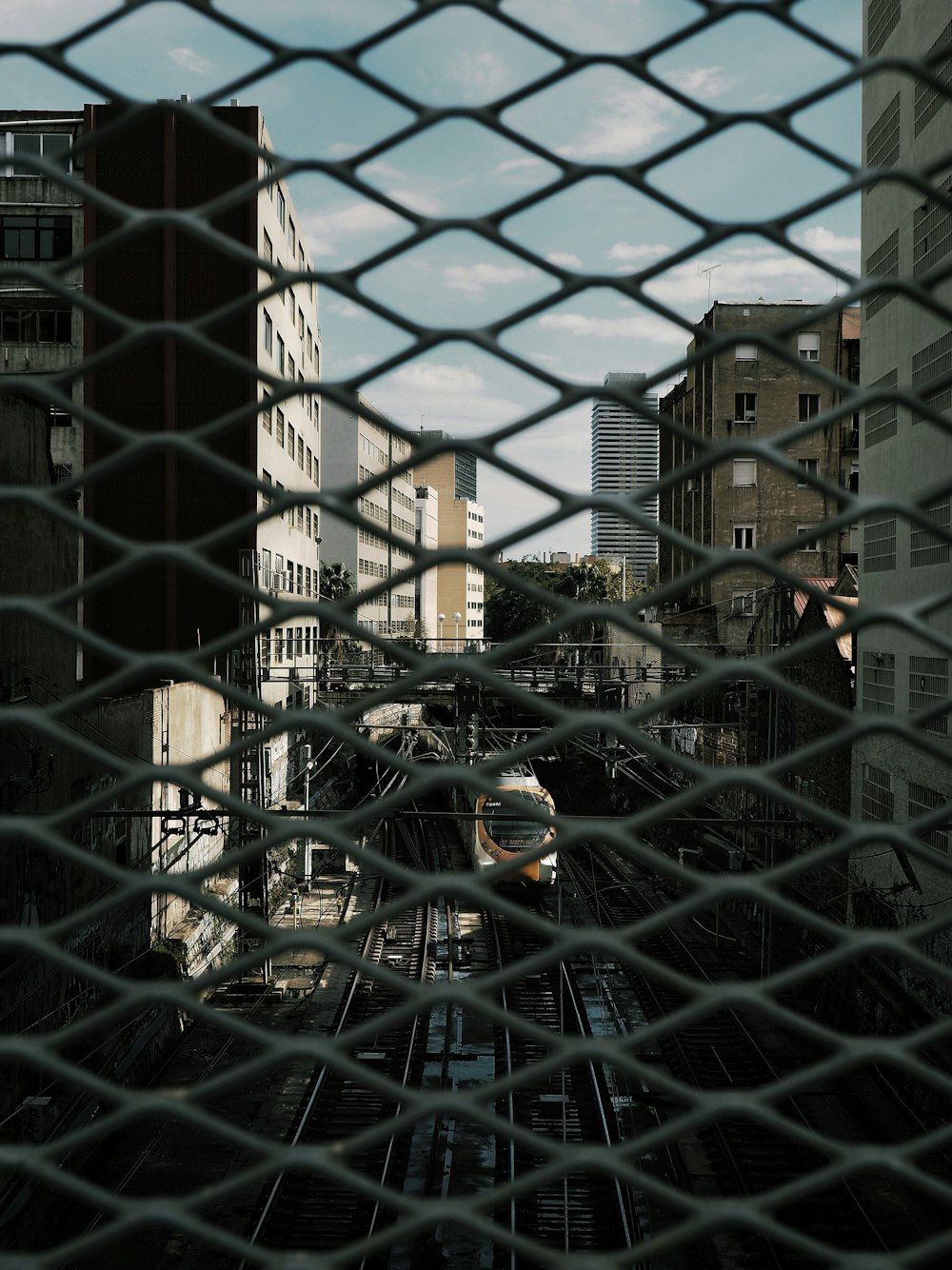 black metal mesh fence near brown concrete building during daytime