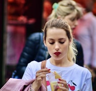 girl in white crew neck t-shirt holding white and red plastic cup