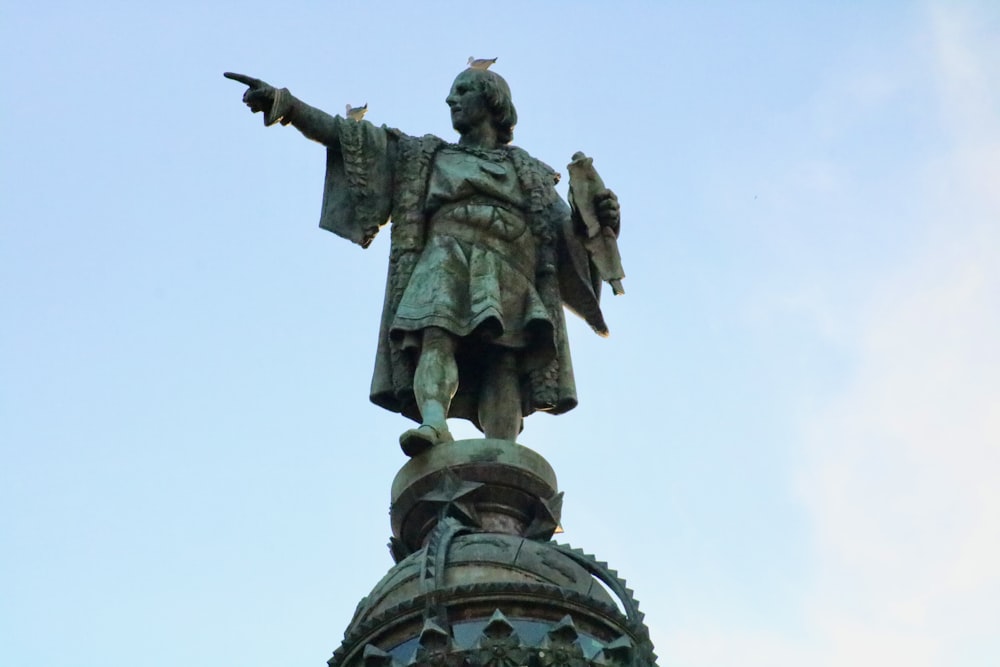 statue of man holding book