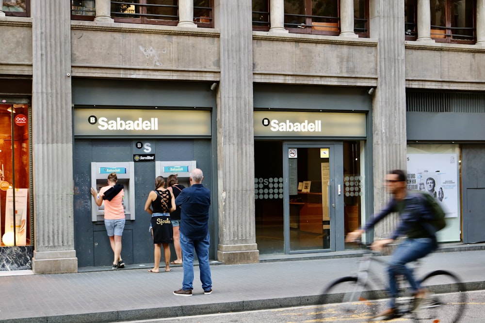 people walking on sidewalk near building during daytime