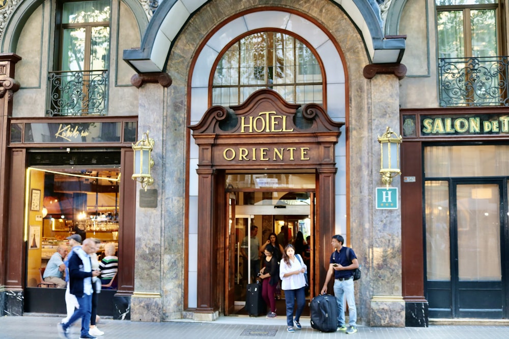 people walking in front of brown wooden building during daytime