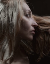 Elegant profile of a man with thick, healthy hair against a dark background