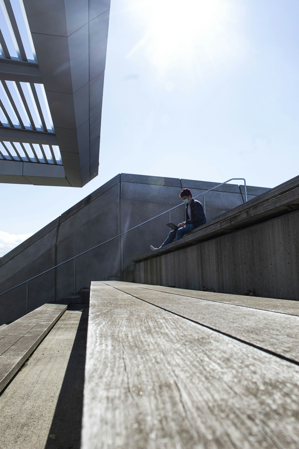 man in black jacket and blue denim jeans walking on gray concrete stairs during daytime