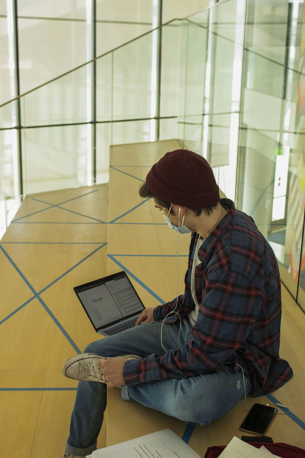 man in red and blue plaid dress shirt using black tablet computer