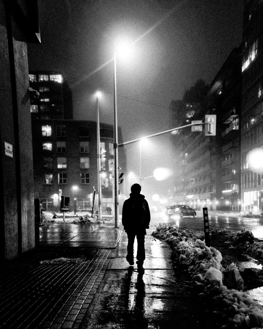uomo che cammina sul marciapiede durante la notte