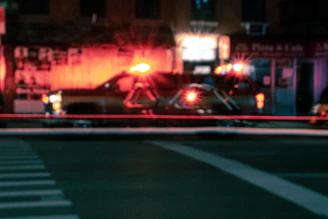 Emergency vehicle with flashing lights assisting a car on a busy Dubai street at night.
