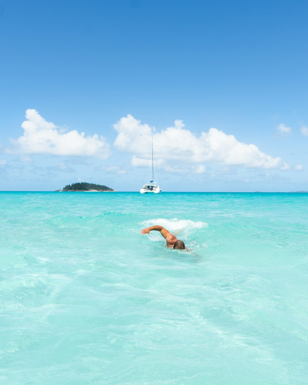 Frau im blauen Bikini schwimmt tagsüber auf dem Meer