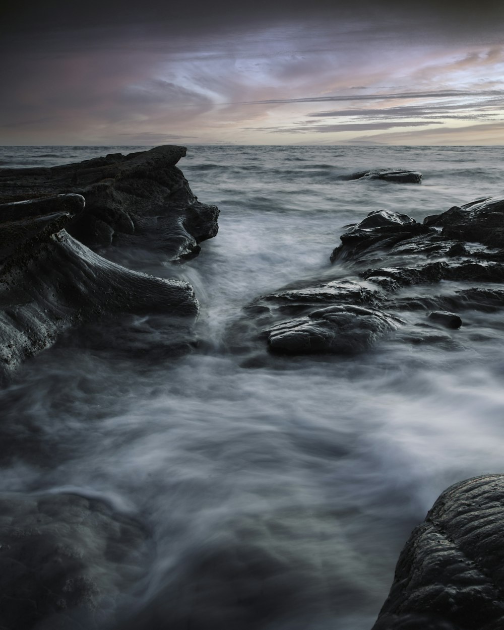 ocean waves crashing on rocks during sunset