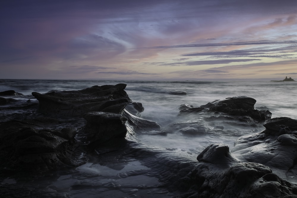 ocean waves crashing on rocks during sunset