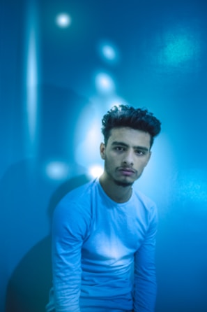 A contemplative figure sitting in meditation surrounded by soft blue and white light.