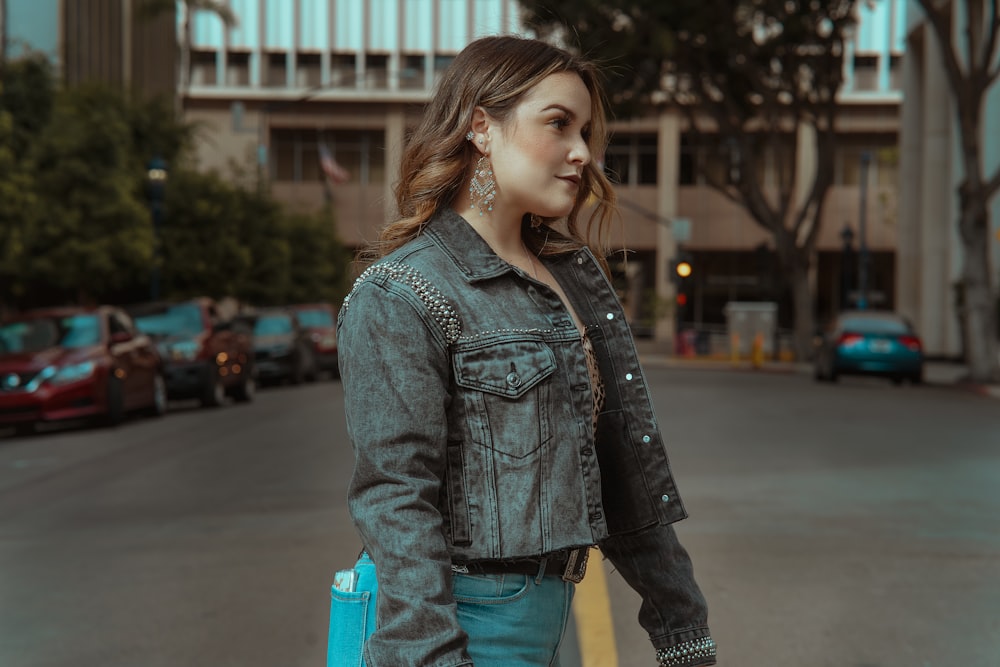 woman in blue denim jacket and blue denim jeans holding blue plastic cup