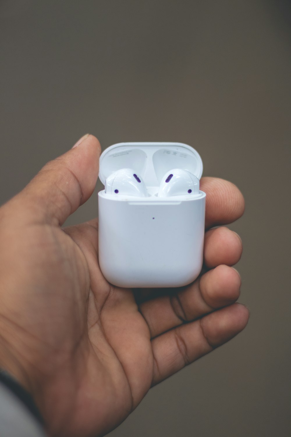 person holding apple earpods with case