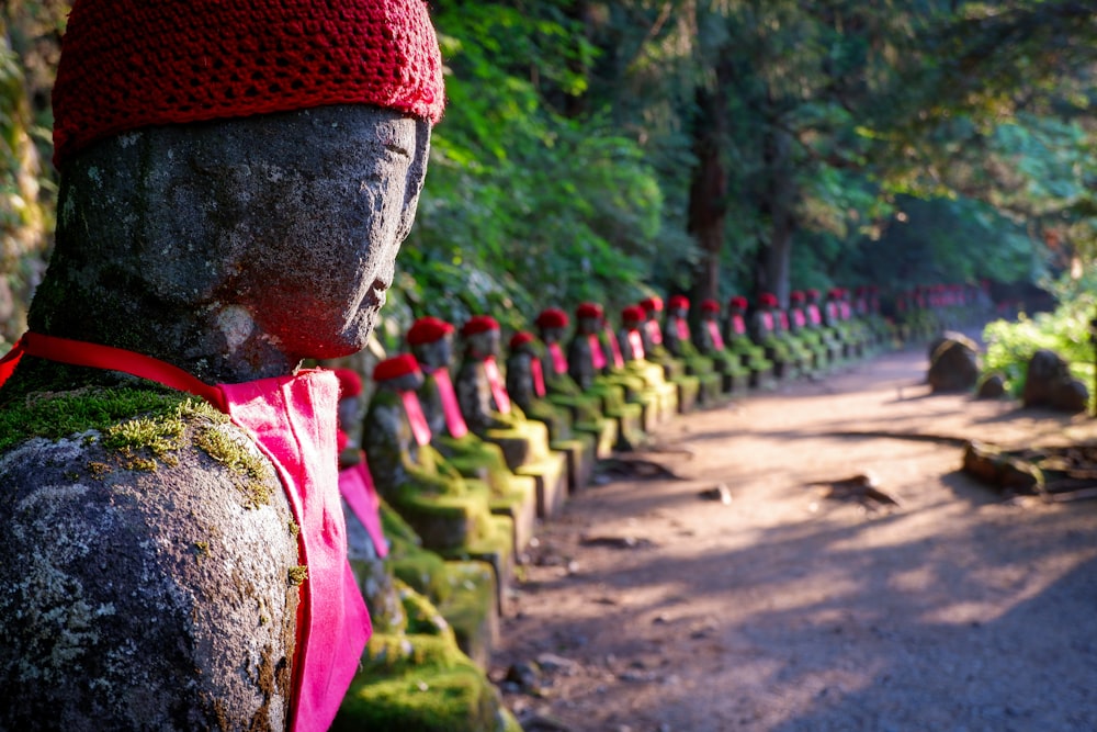 man in red knit cap and green shirt standing on brown dirt road during daytime